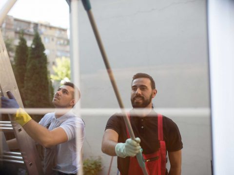 Fassade wird von zwei Männern geputzt